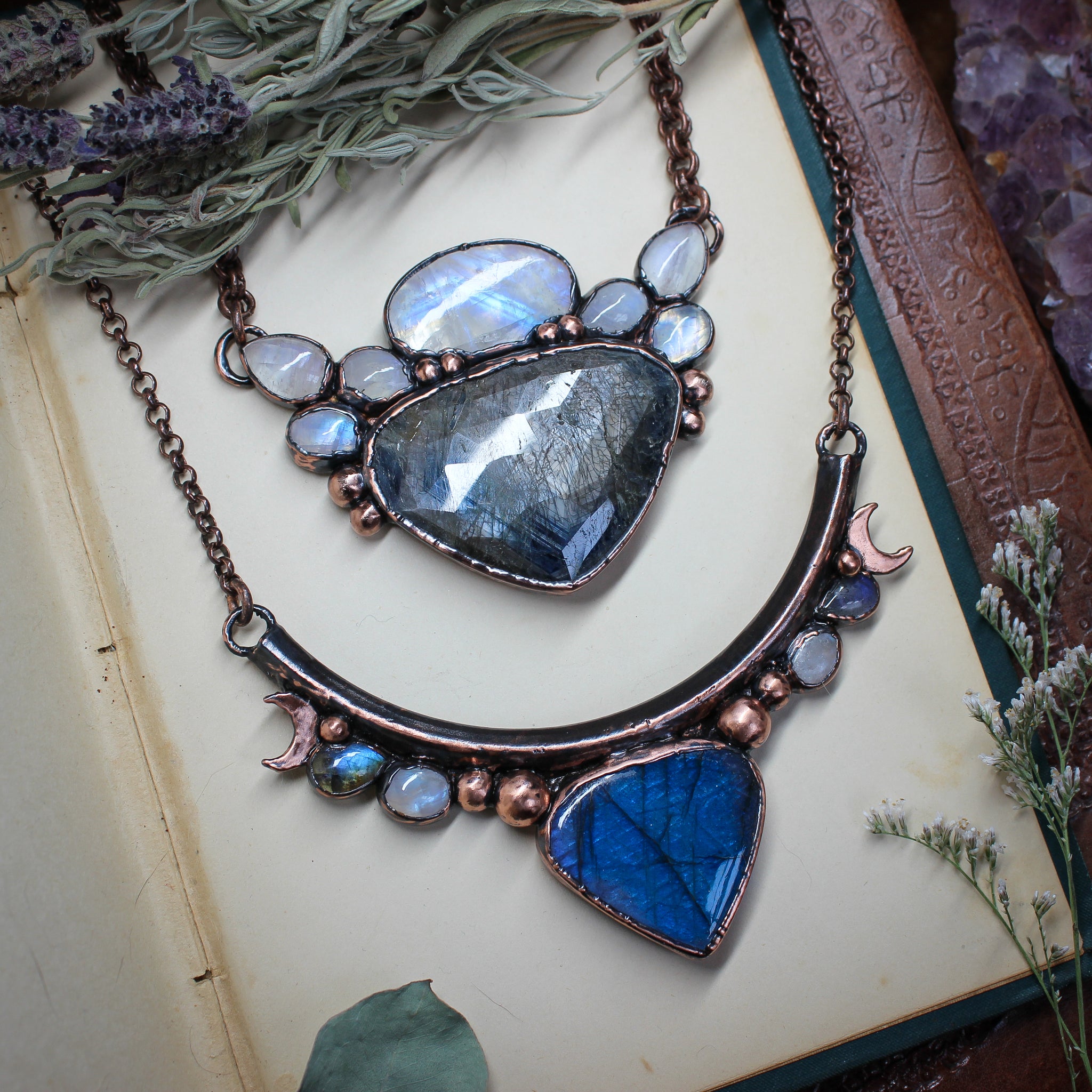 two fantasy style crystal necklaces. One of the necklaces has sapphires, the other has blue labradorite