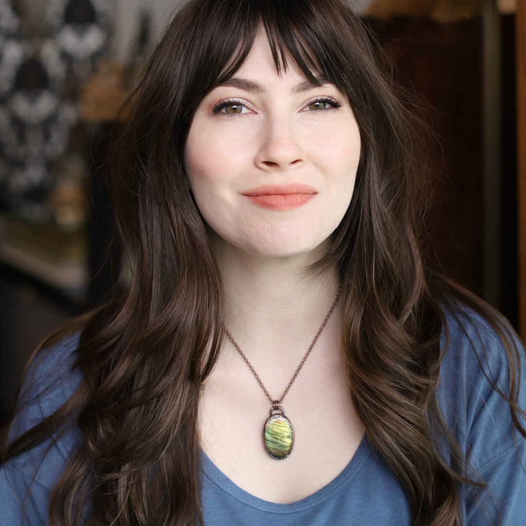 a woman wearing an electroformed labradorite necklace that has green flash.